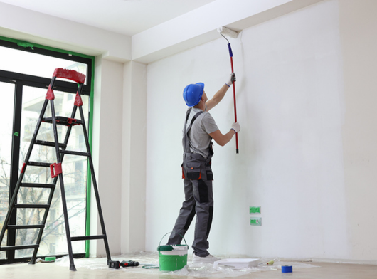 peintre entrain d'utiliser un rouleau de peinture